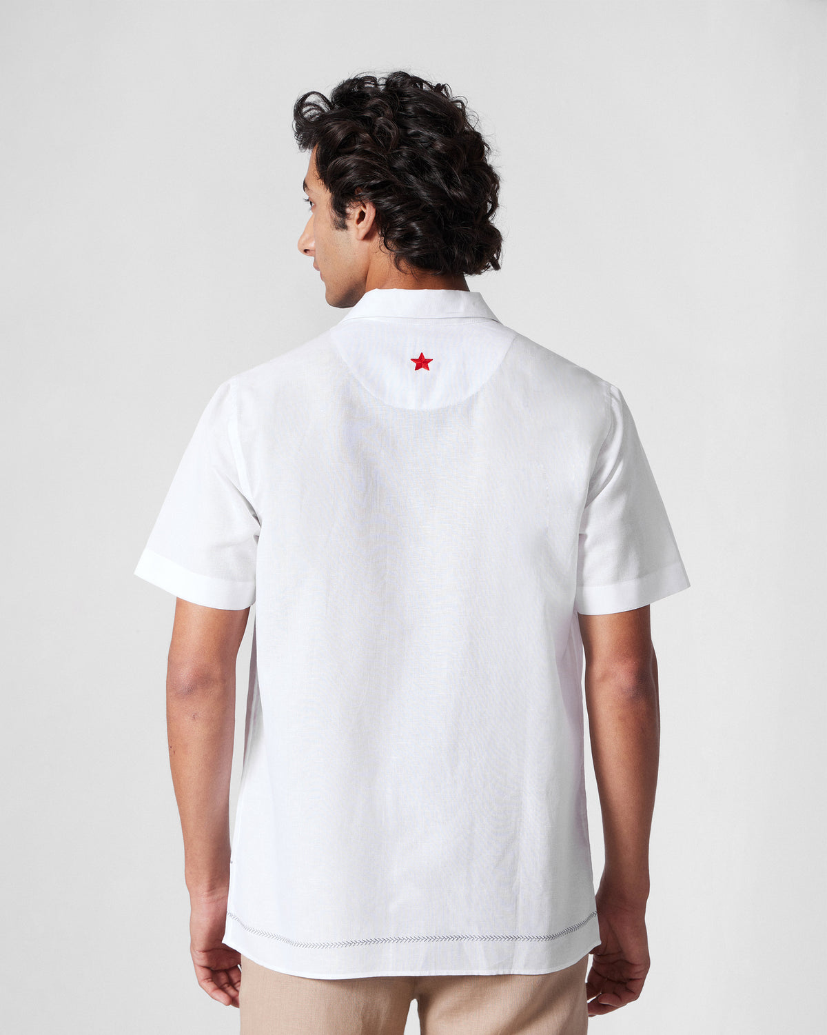 Back of a white Delta shirt with a red star on the yoke.