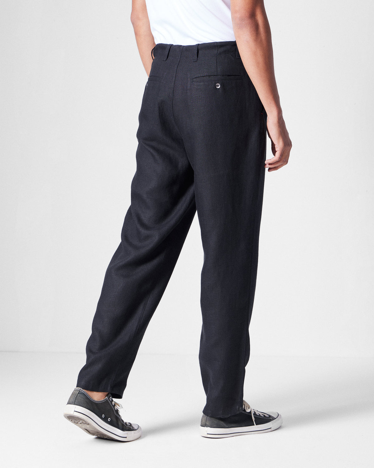 Back of black Karo Pants with a buttoned welt pocket.
