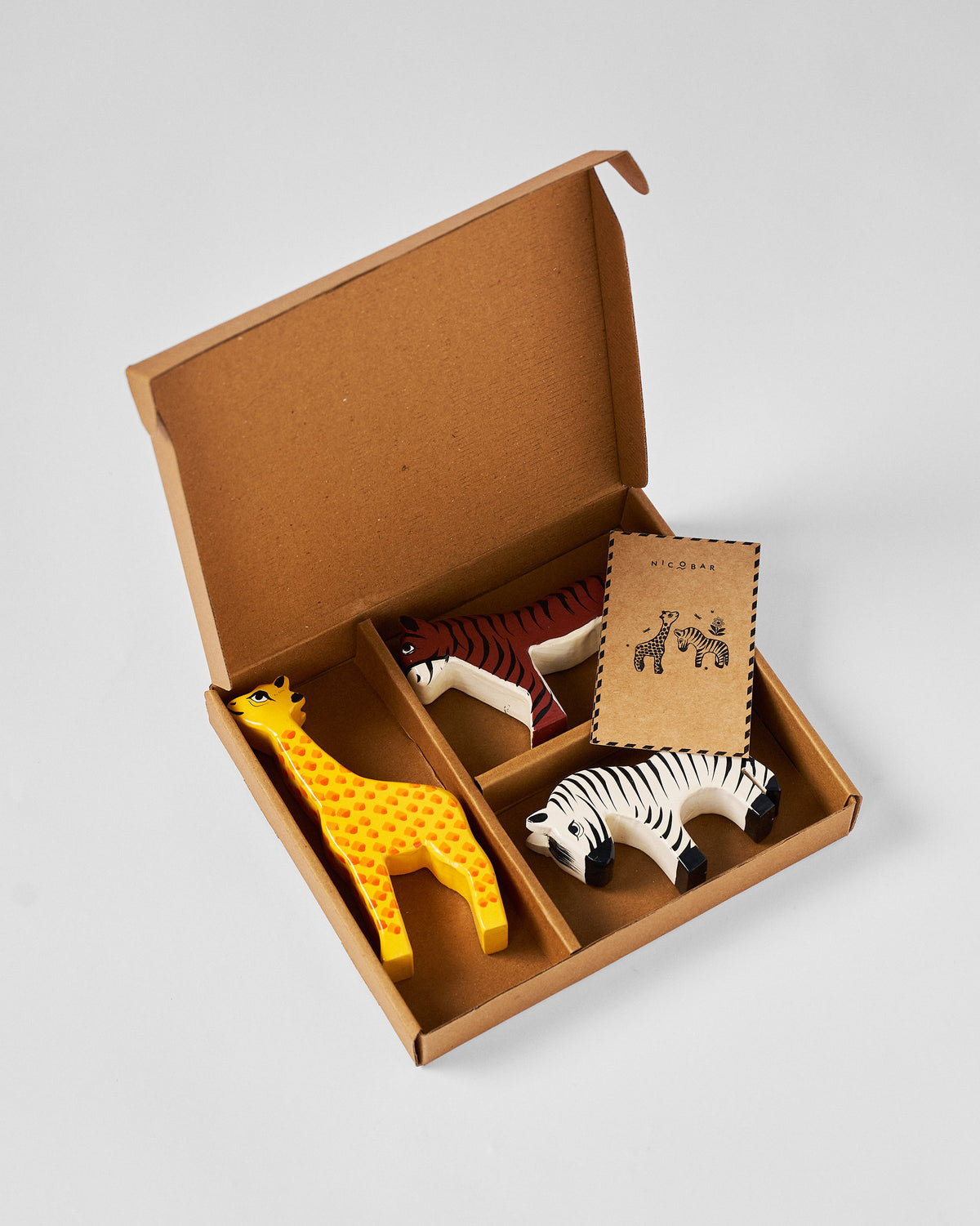 Nicofari gift set packed in an open kraft box, with the figures and a small card.