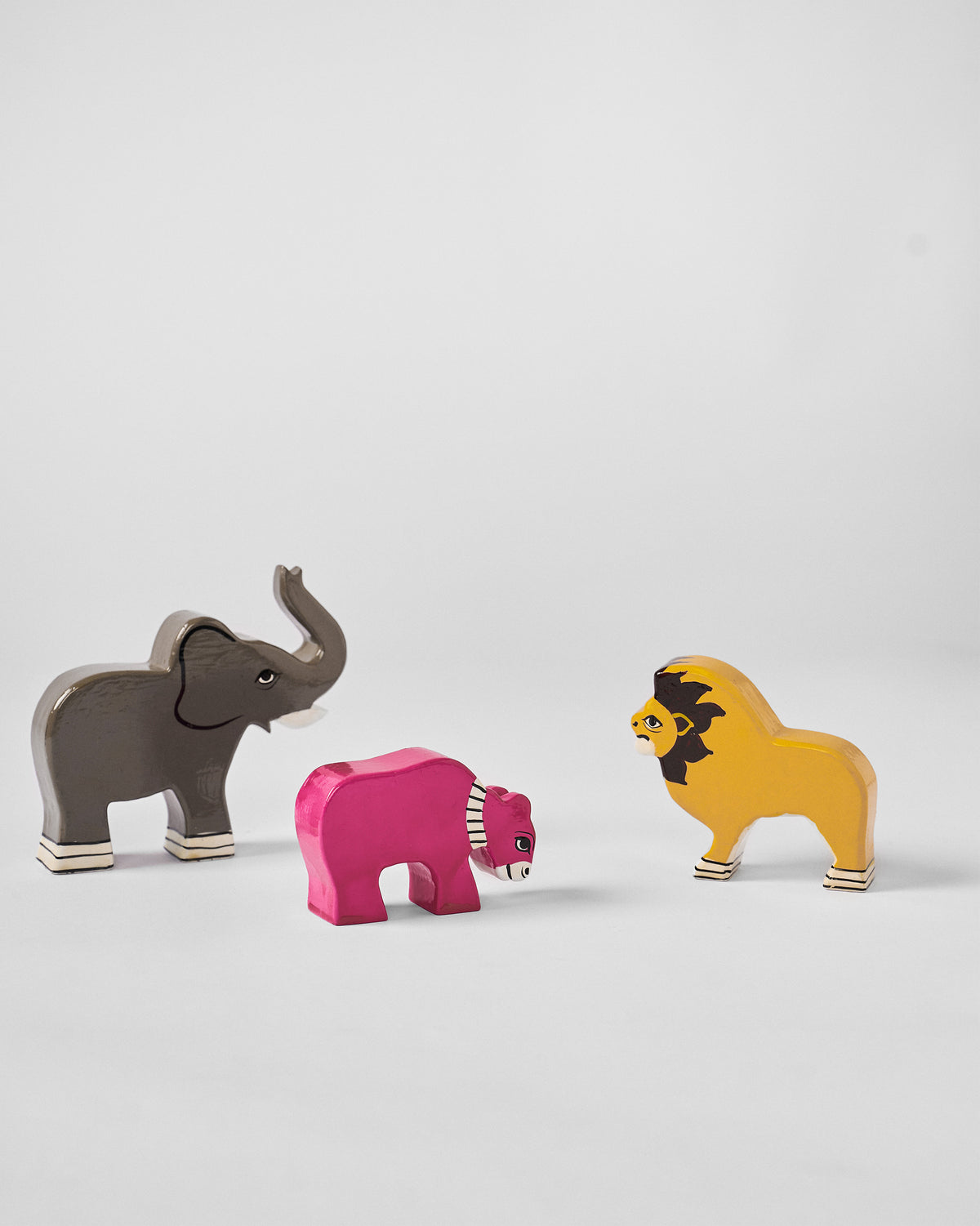 Nicojungle elephant, pink figure and lion figures standing apart.