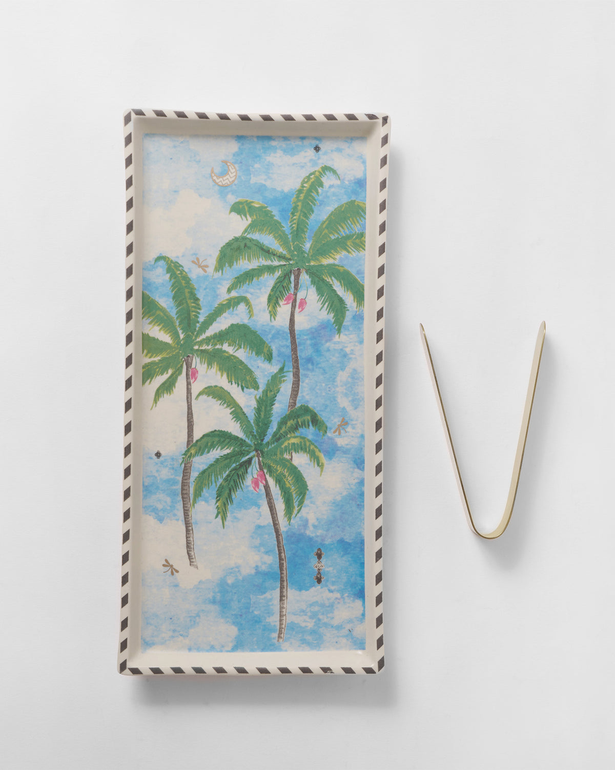 Haathi cookie tray with palm print laid beside a pair of gold tongs.