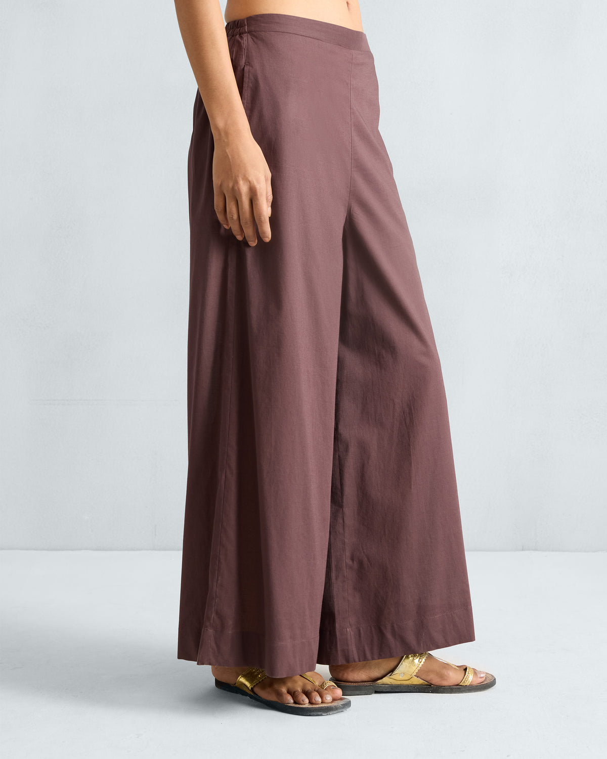 Side view of chocolate plum Basic pyjamas showing the wide-leg drape.