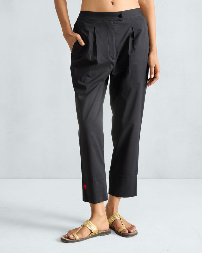 Black Narrow pants with front pleats and a red embroidered heart at the cuff.