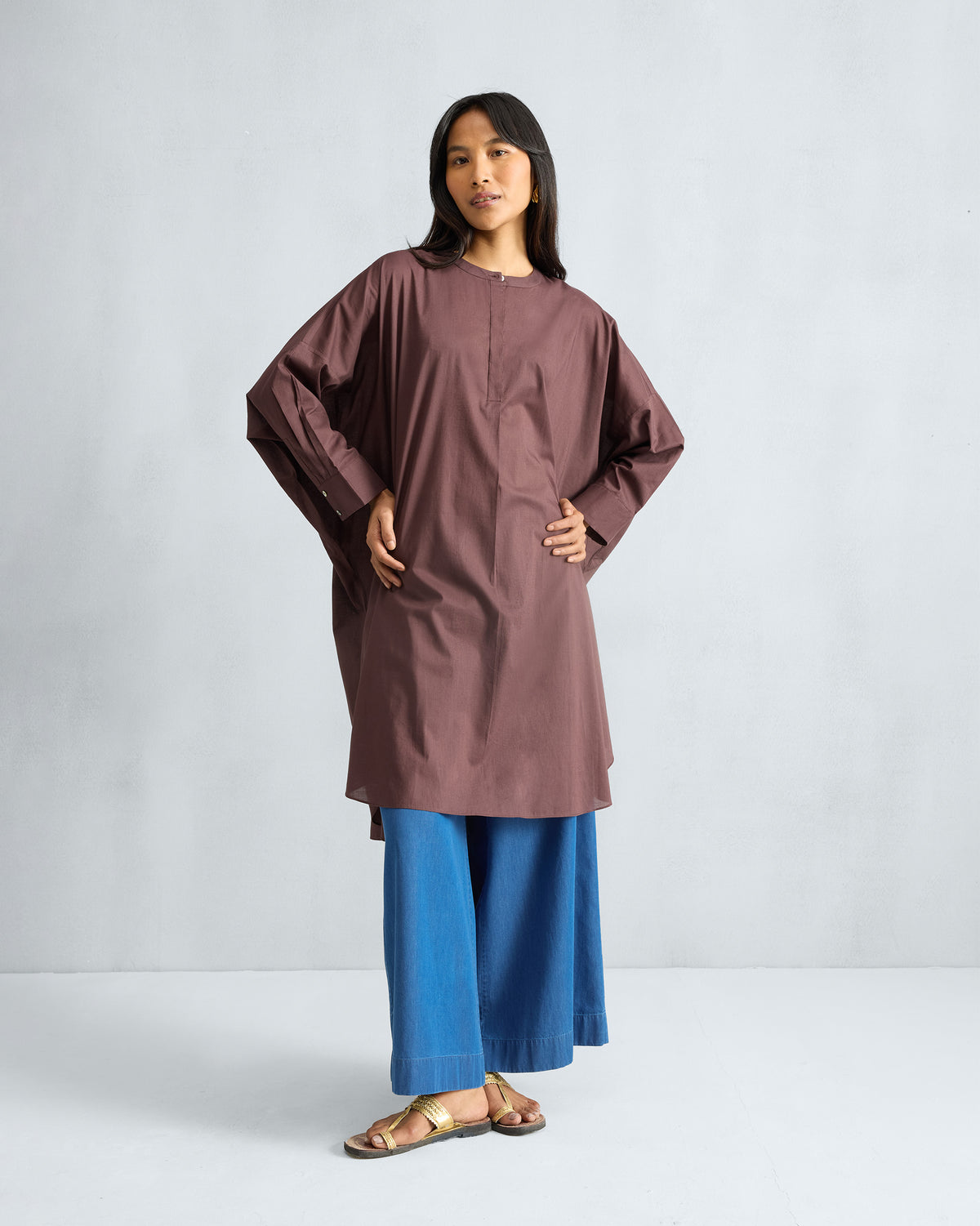 Person wearing a chocolate plum Lazy Sunday tunic with a relaxed oversized fit.