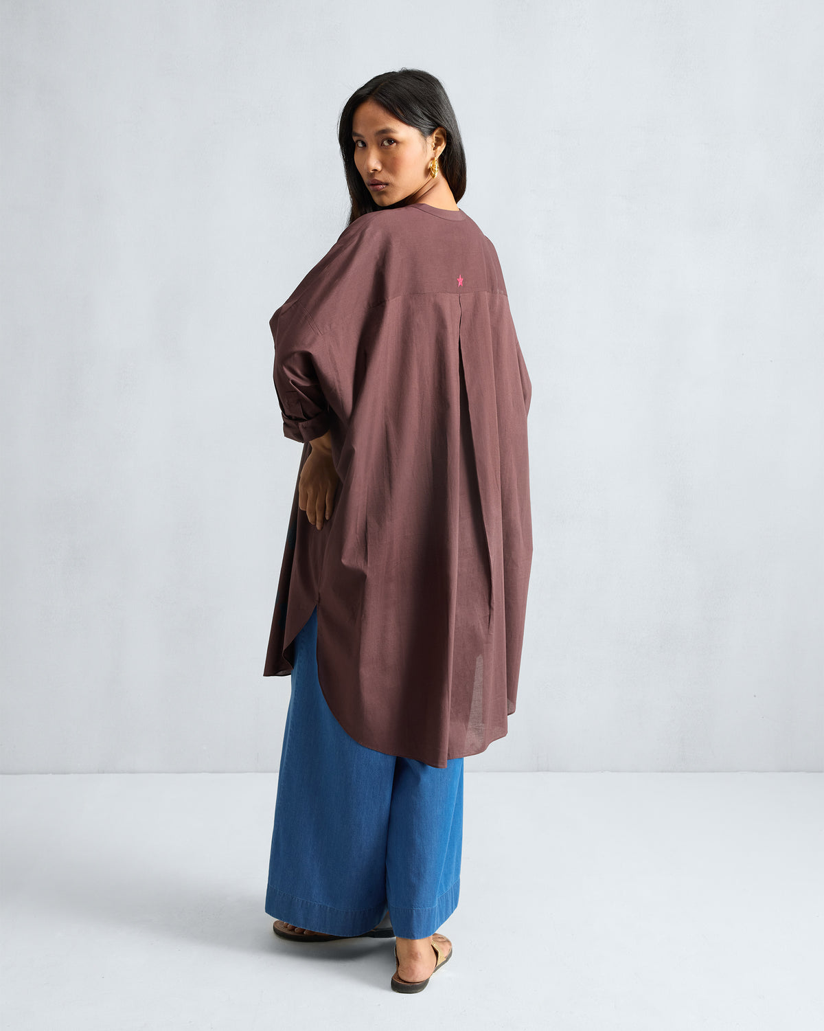 Back of a chocolate plum Lazy Sunday tunic with a yoke pleat and red star.