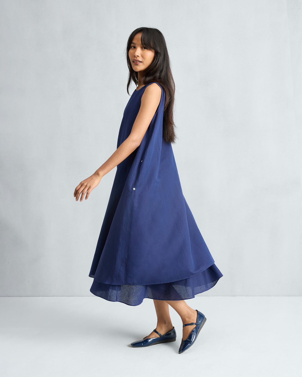 Ink blue Double Layer Dress with a flared tiered hem in motion.