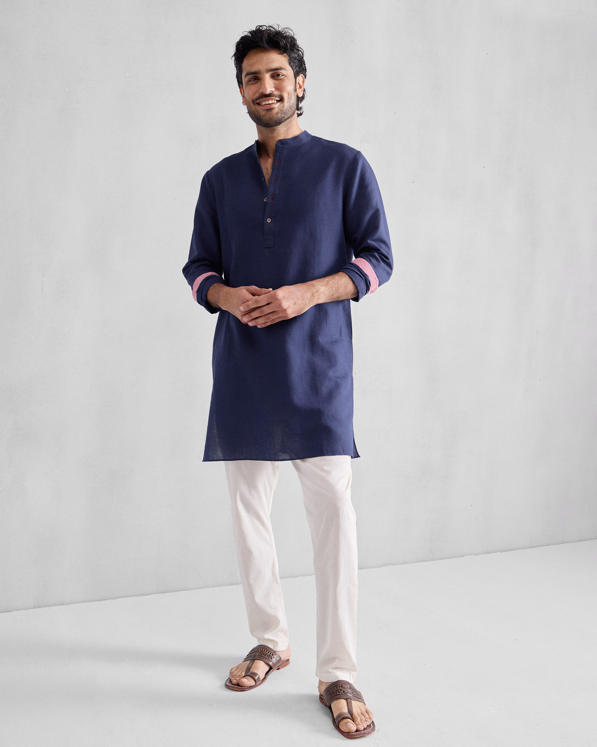 Person wearing an ink blue Chandni Chowk Kurta with sleeves rolled to show pink cuffs.