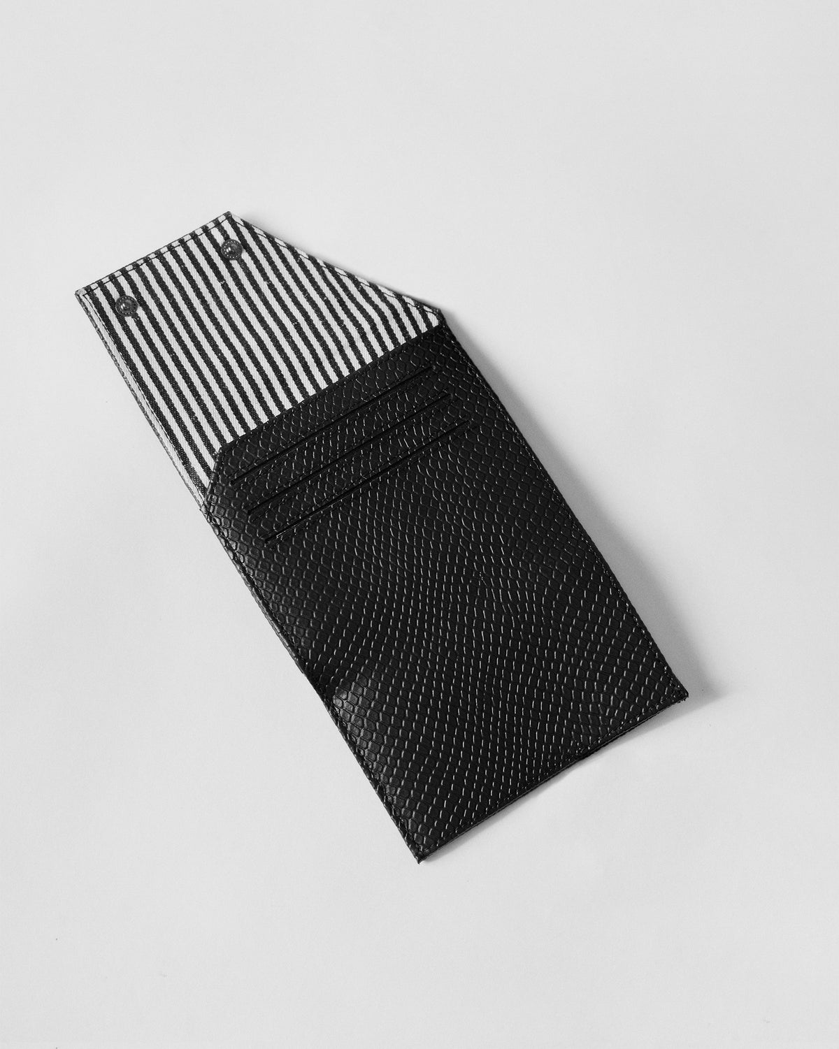 Open black tri-fold wallet with striped lining and three card slots inside.