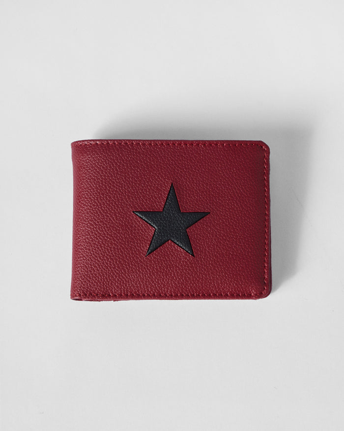 Closed red bi-fold wallet with a black star on pebbled leather.