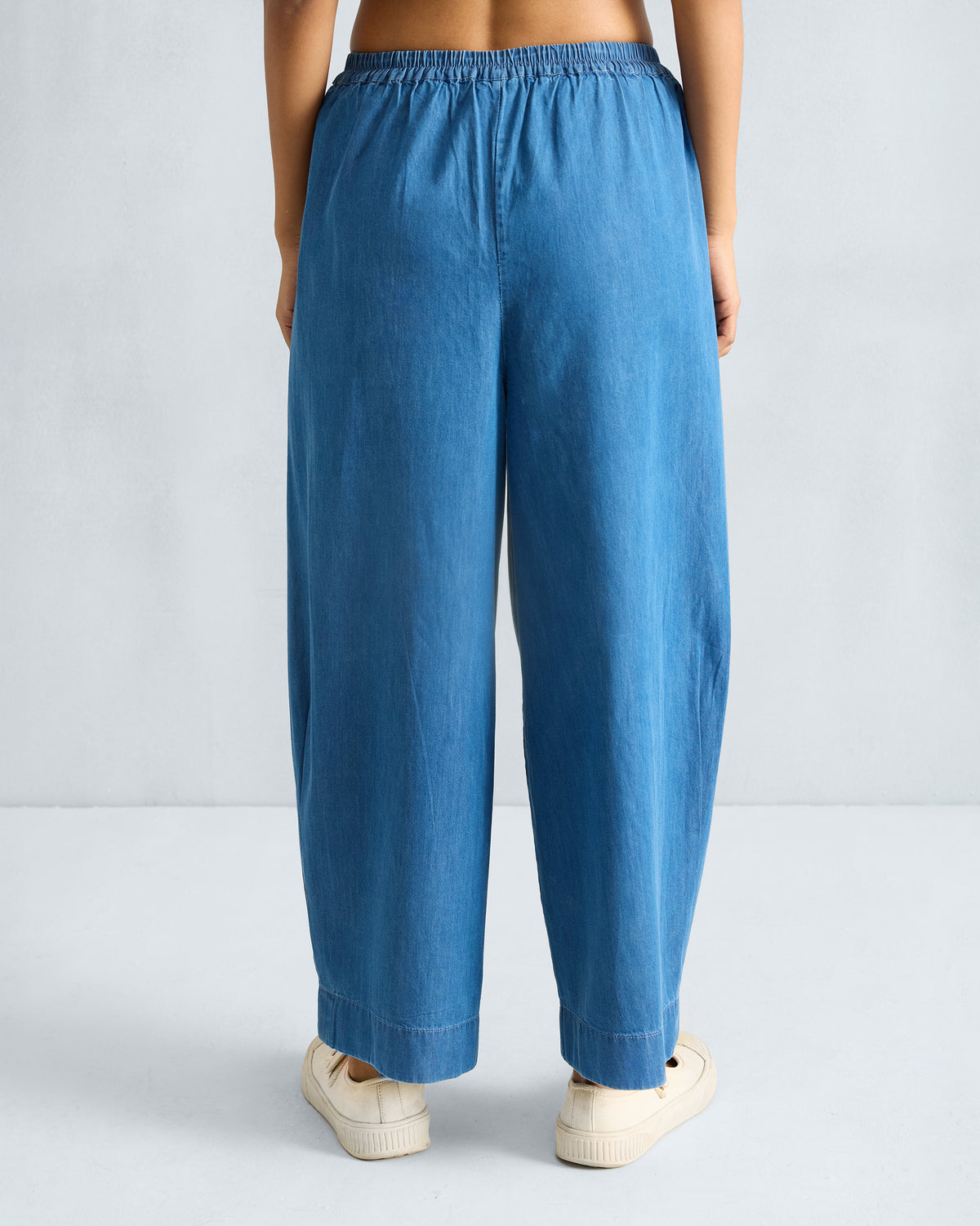 Back of denim Serene pants with a gathered waist and wide legs.