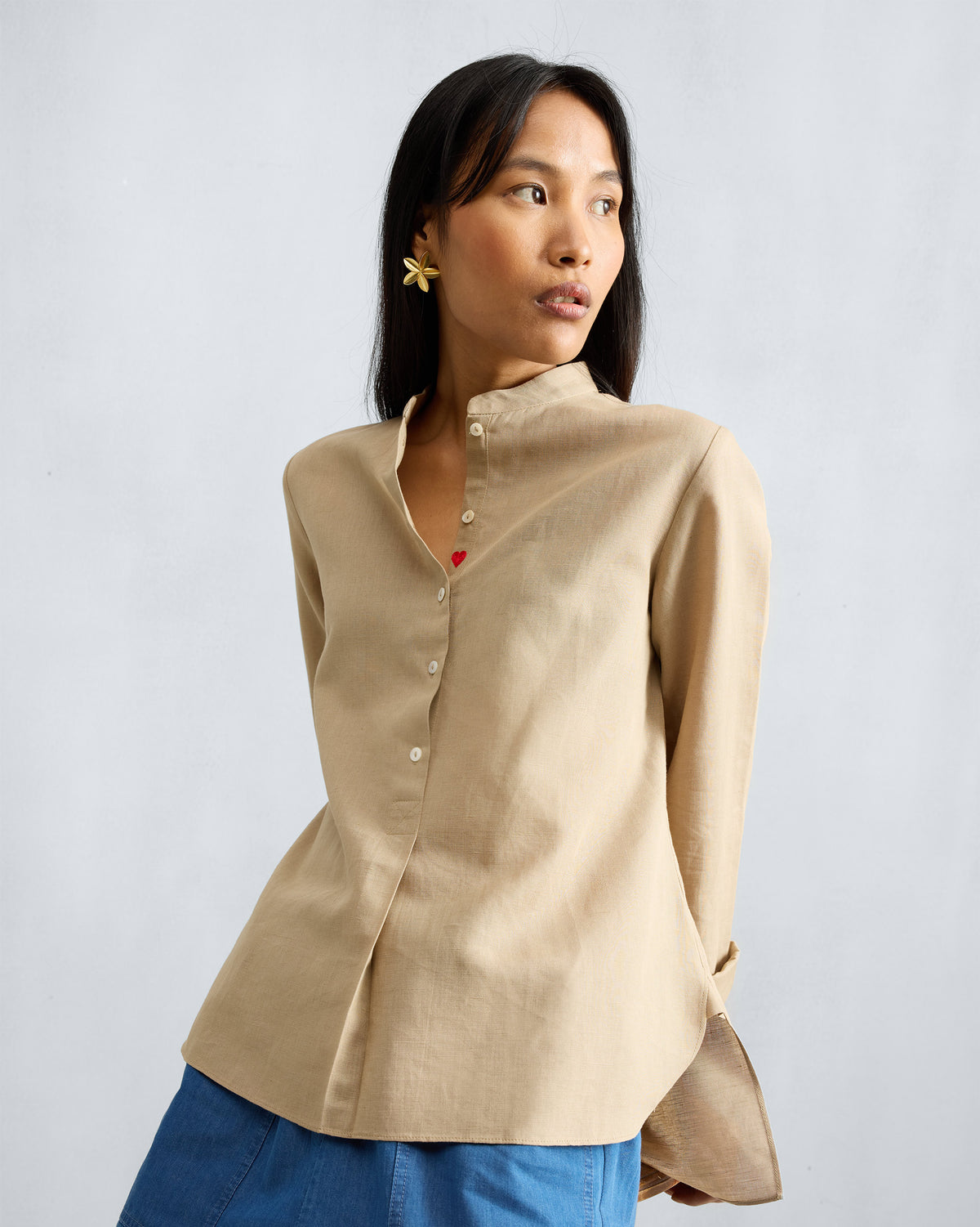 Beige mandarin collar top with a red embroidered heart on the placket.