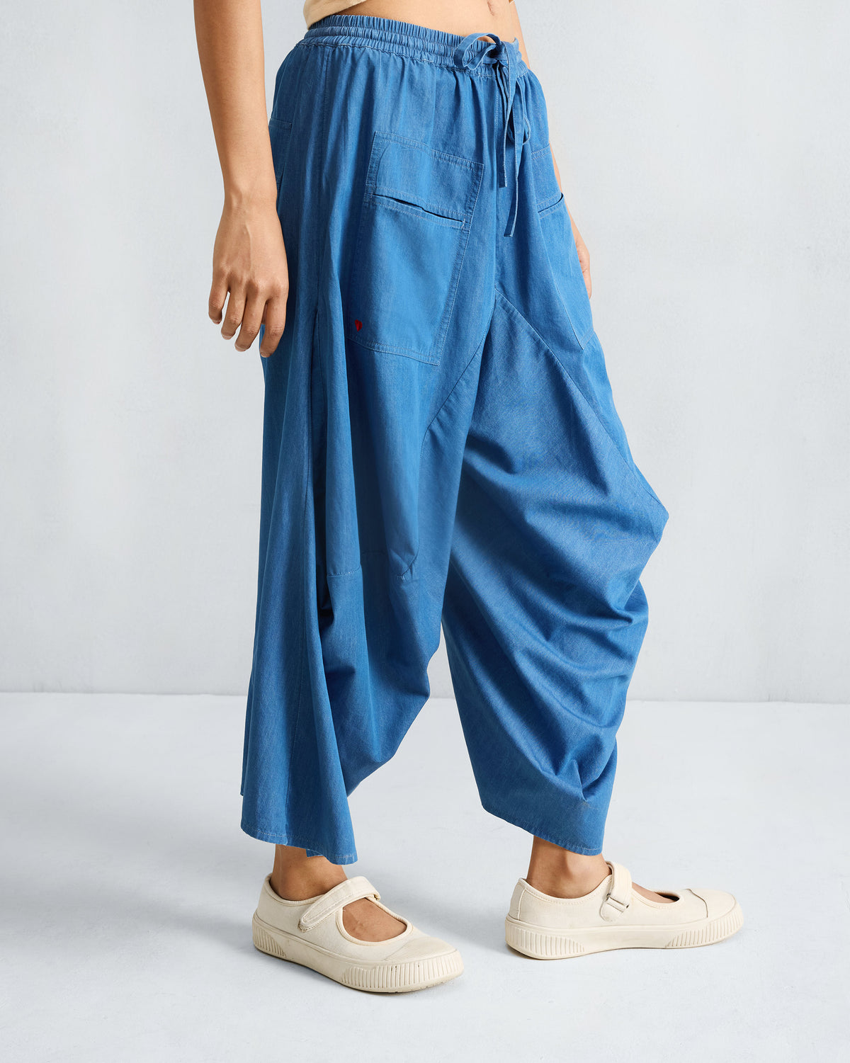 Denim blue Yoka Trousers with a red heart on the pocket.