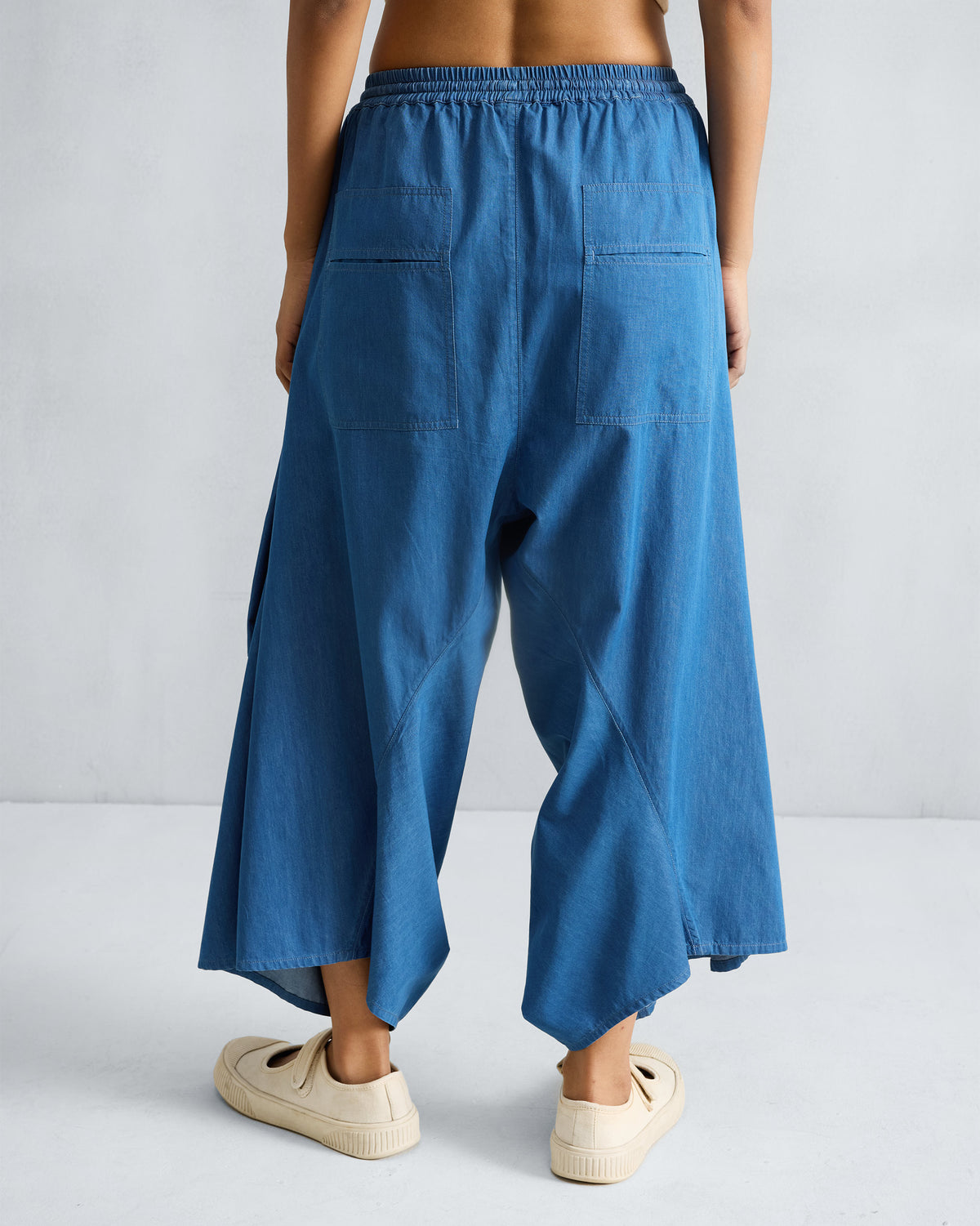 Back of denim blue Yoka Trousers with patch pockets.