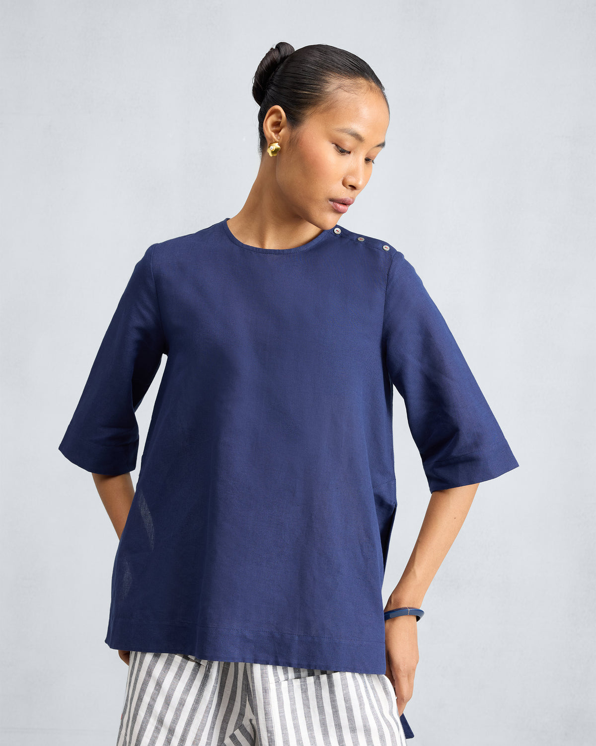 Ink blue High Slit Top with a round neck and pearl shoulder buttons.