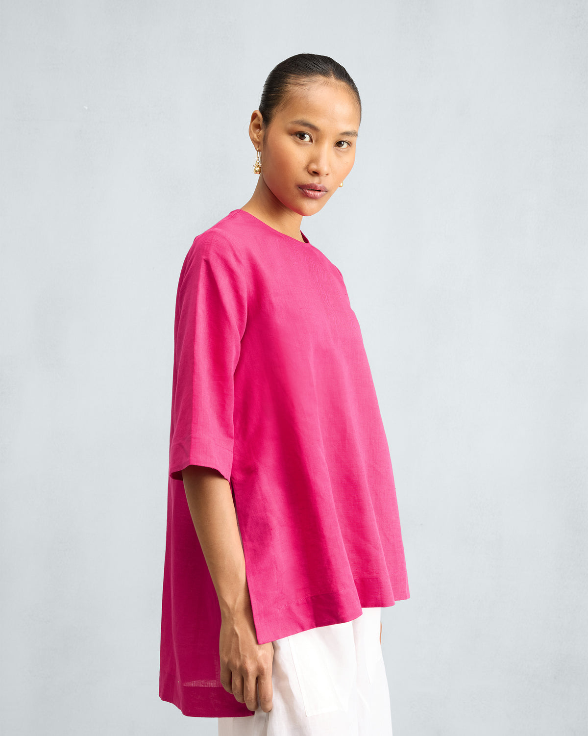 Person wearing a fuchsia top with a deep side slit.