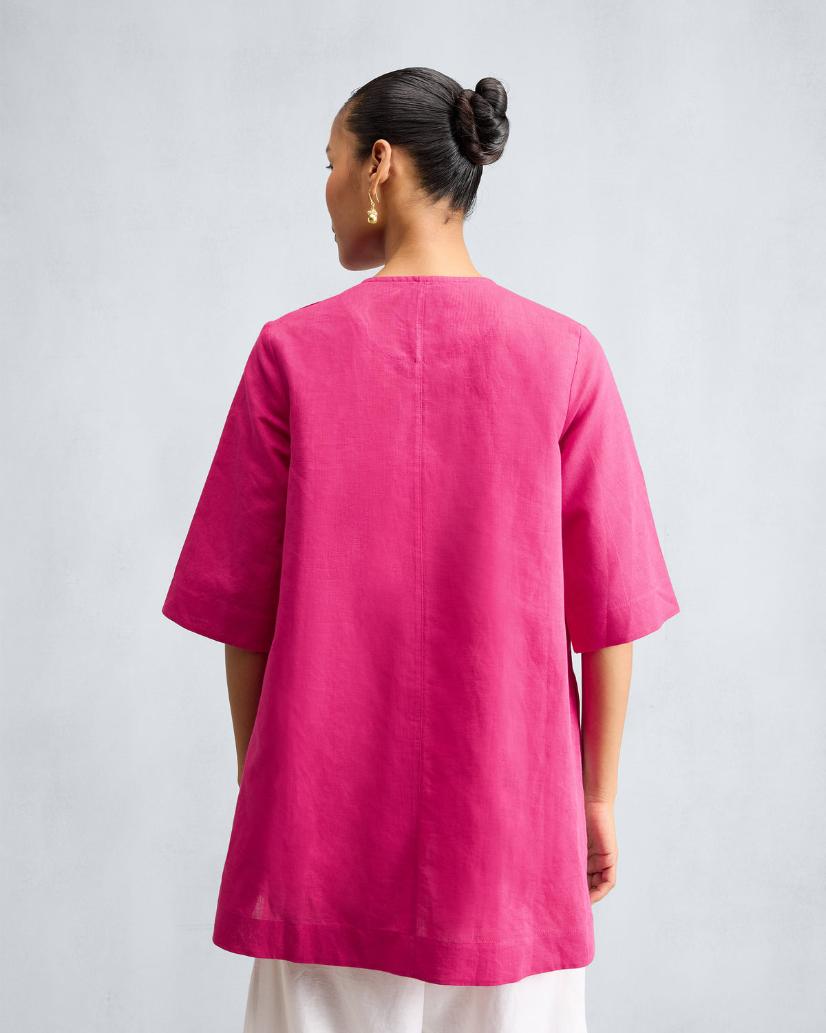 Back of a fuchsia loose top with a centre seam.