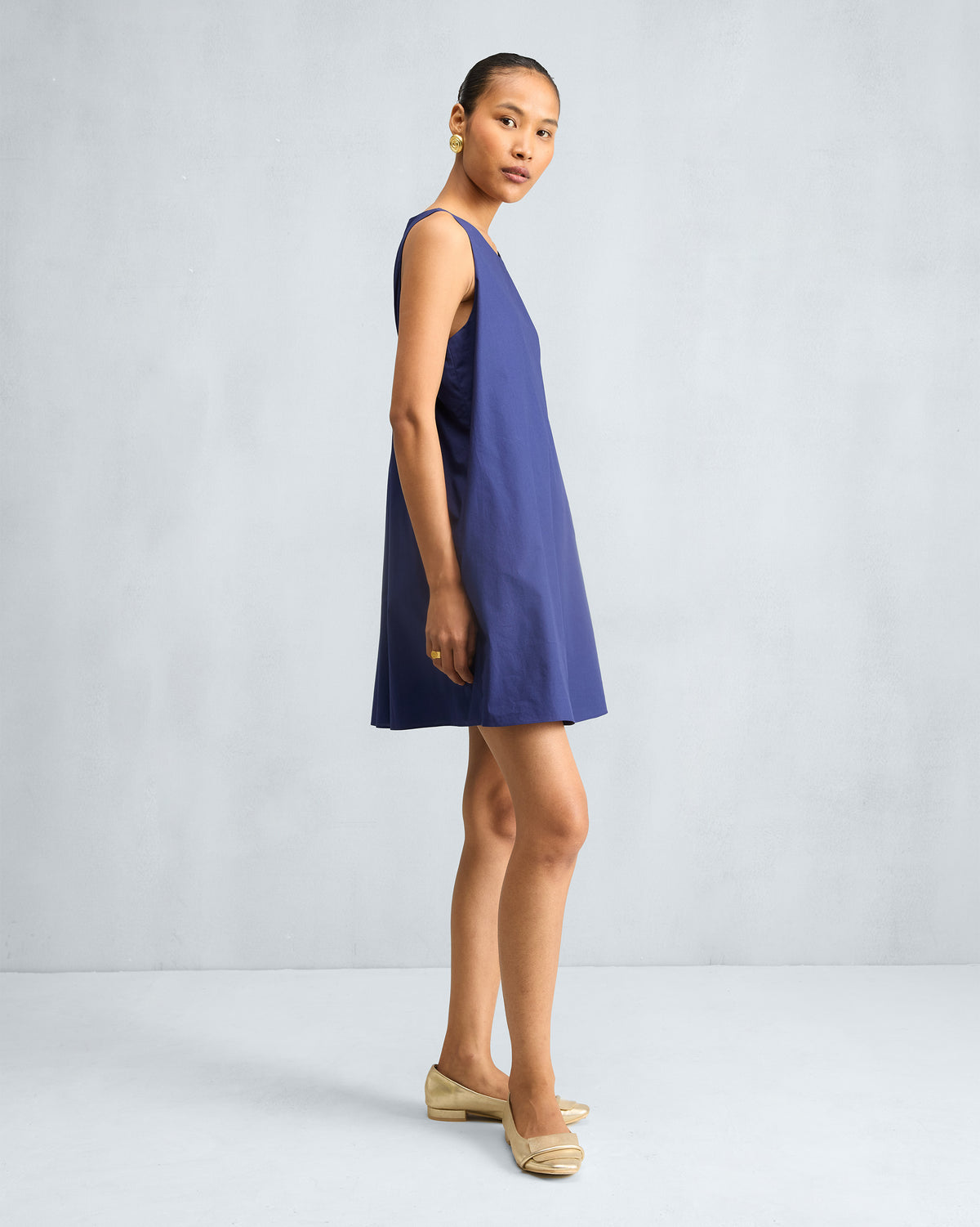 Side view of an ink blue short racerback dress.