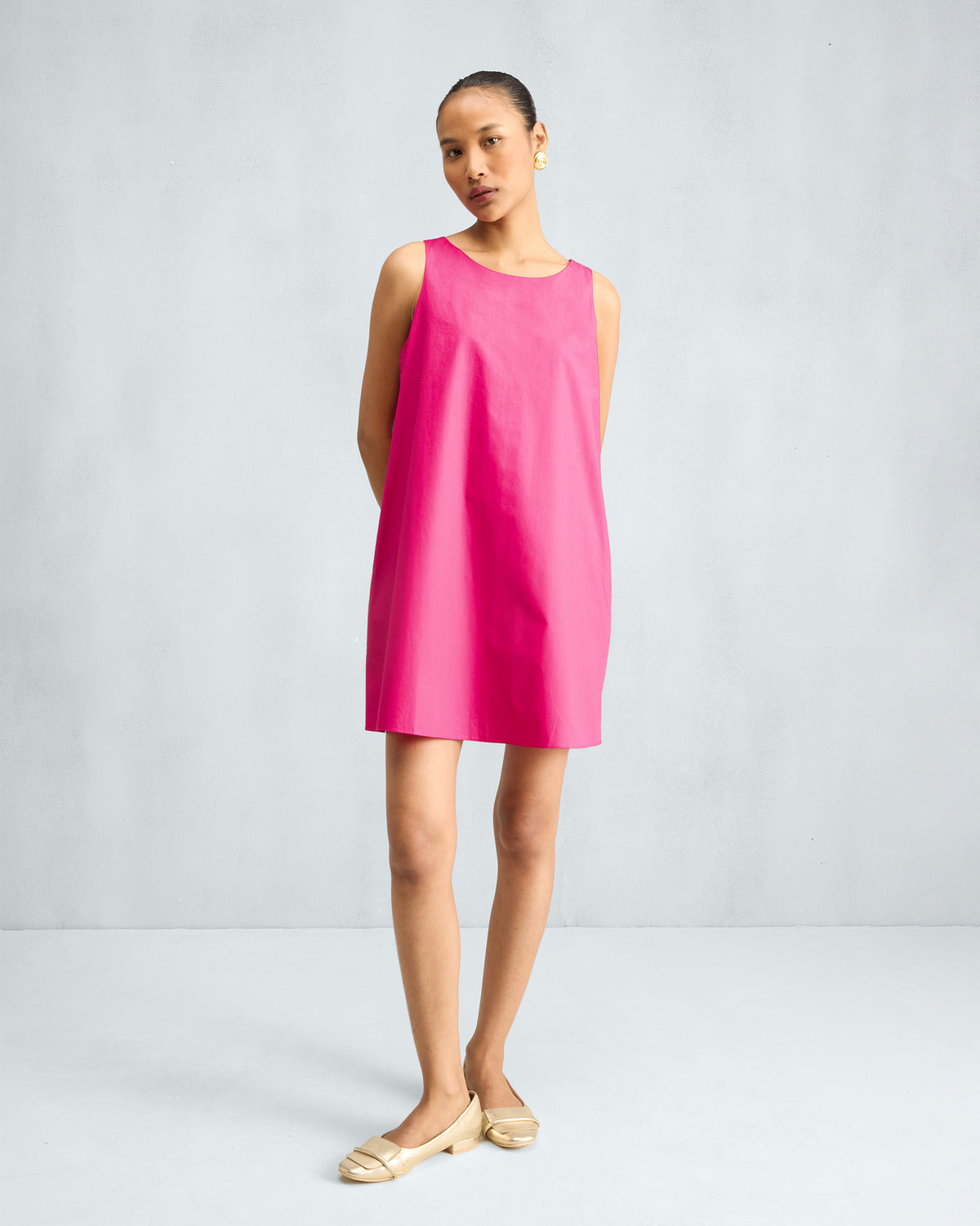 Person wearing a fuchsia short racerback dress.