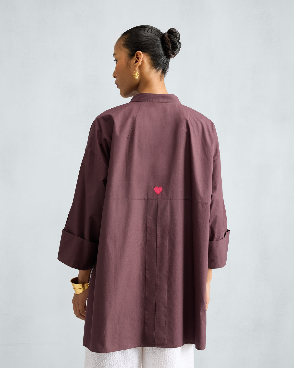 Back of a chocolate plum Cirrus shirt with a pink heart embroidery.