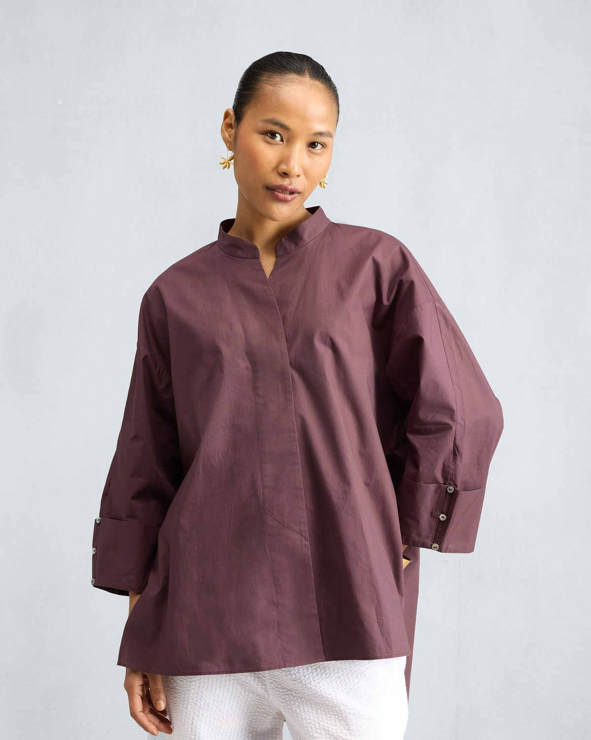 Person wearing a chocolate plum Cirrus shirt with a mandarin collar.