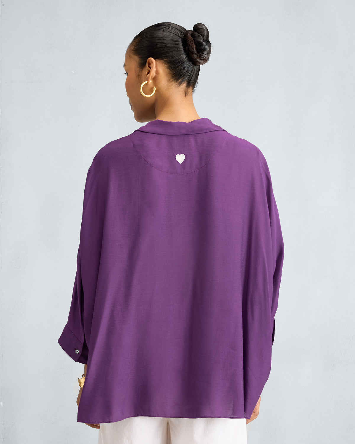 Back of a purple Boxy shirt with a white embroidered heart.