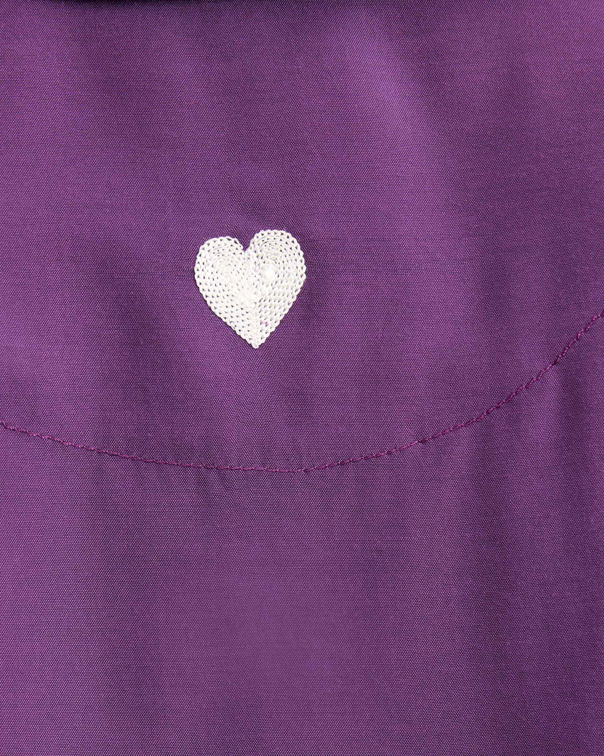 Close-up of a white sequined heart on a purple Boxy shirt.