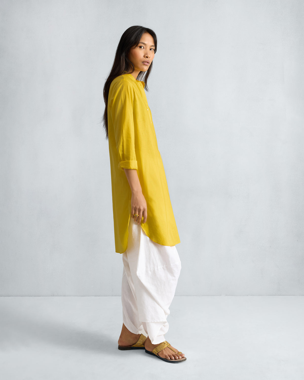 Side view of a yellow mid-length kurta with side slits.