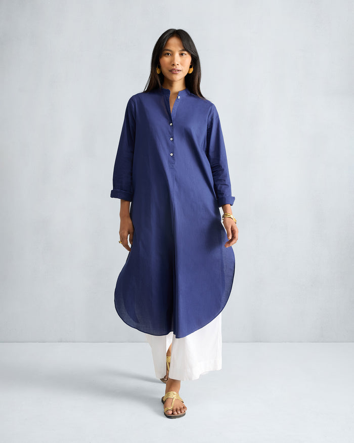 Person wearing an ink blue long kurta with a mandarin collar and curved hem.