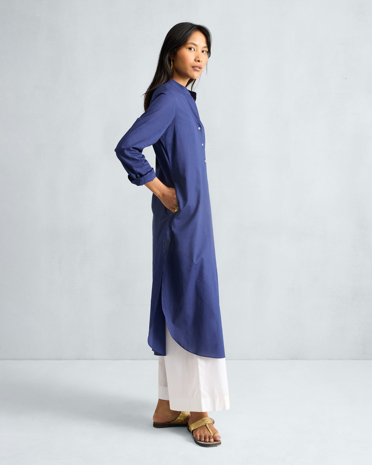Side view of an ink blue long kurta with side slits and a curved hem.