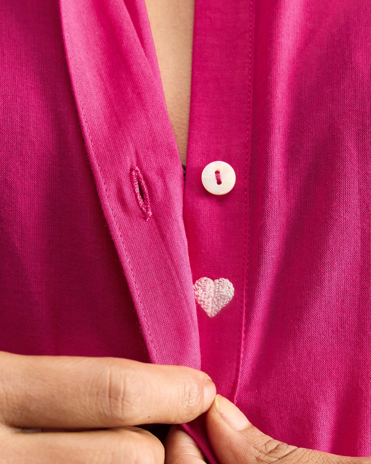 Close-up of a white heart embroidery inside a fuchsia Basic Long Kurta placket.