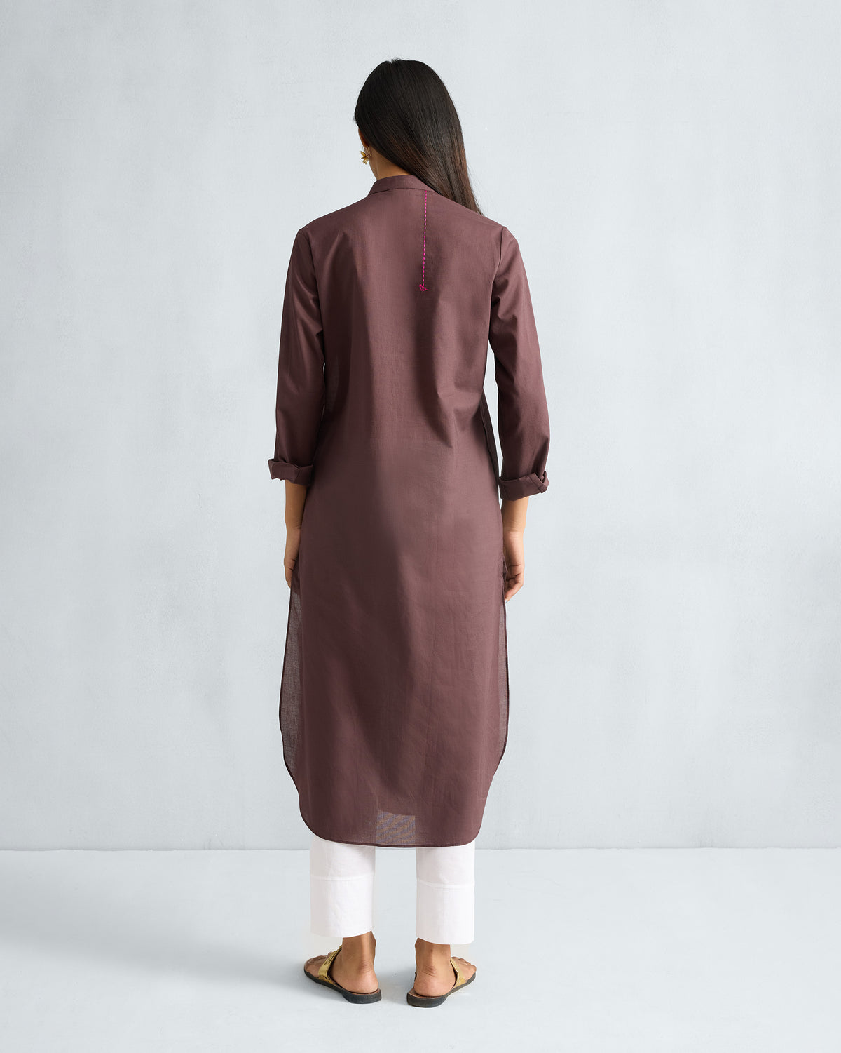 Back of a chocolate plum long kurta with a pink embroidered parrot.