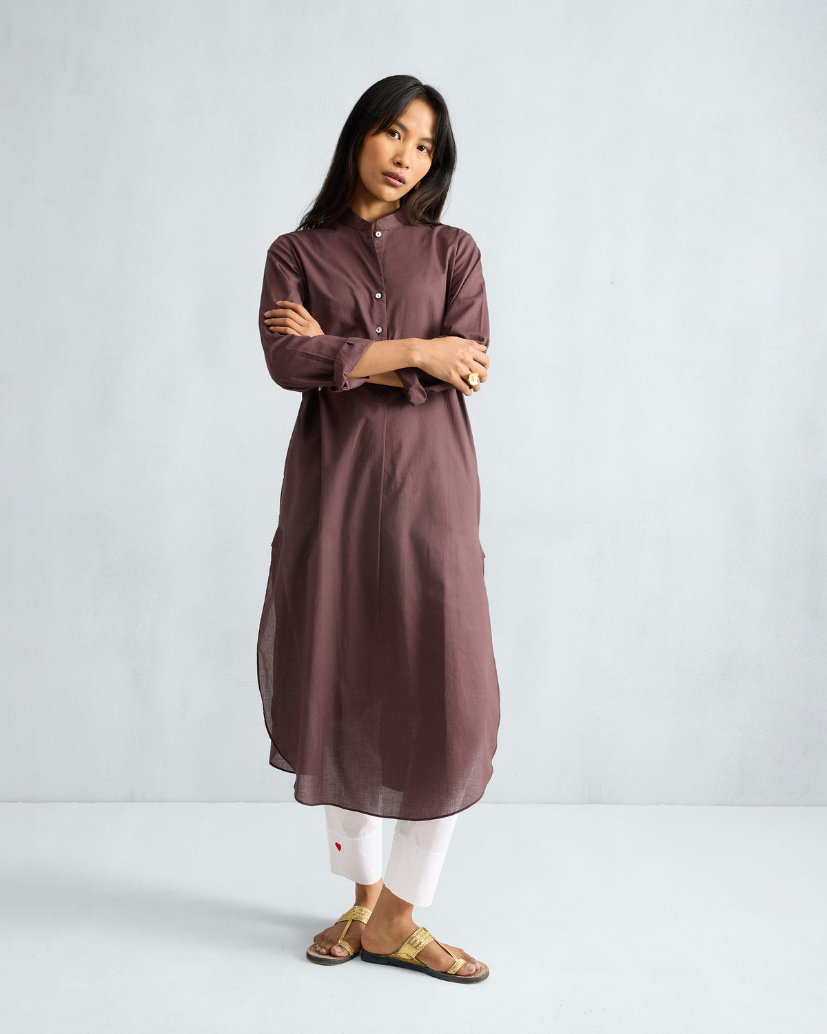 Person wearing a chocolate plum long kurta with a mandarin collar and curved hem.