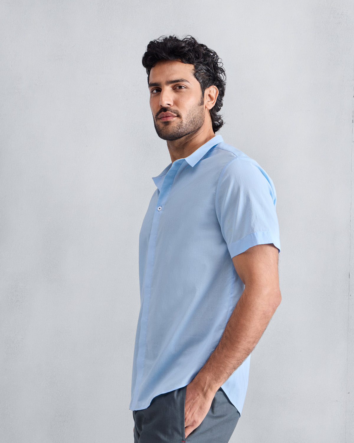 Side view of a light blue Riverine shirt worn by a person.