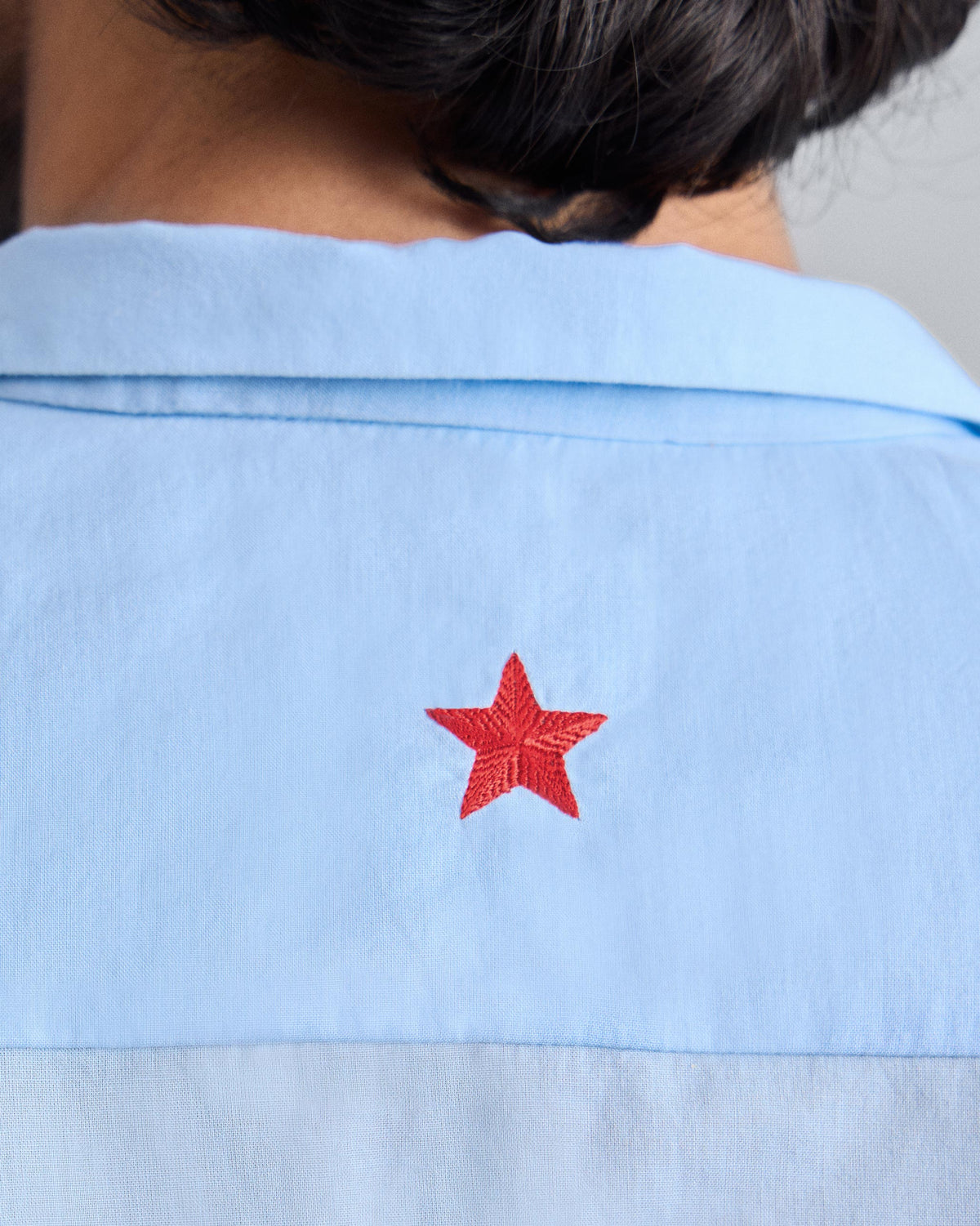 Close-up of a light blue Riverine shirt back with a red embroidered star.
