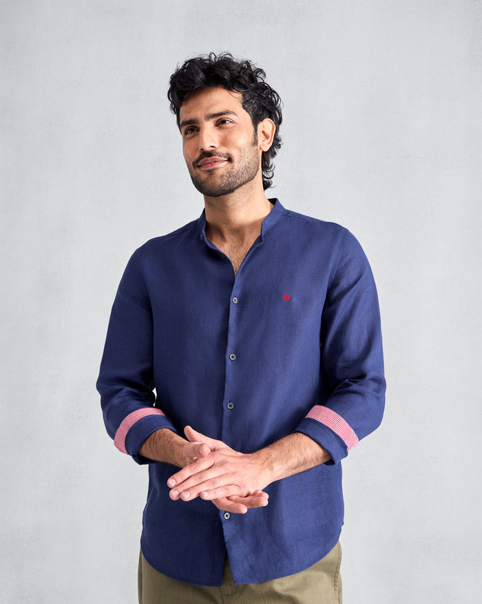Person wearing an ink blue Nawab shirt with coral cuff lining.