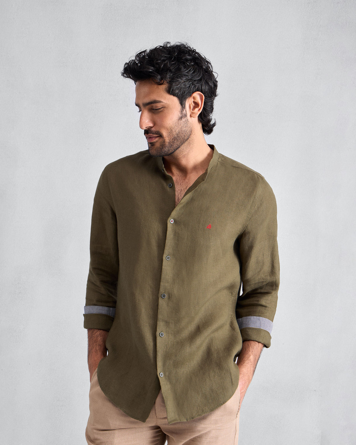 Person wearing an olive Nawab Shirt with rolled sleeves showing contrast cuff lining.