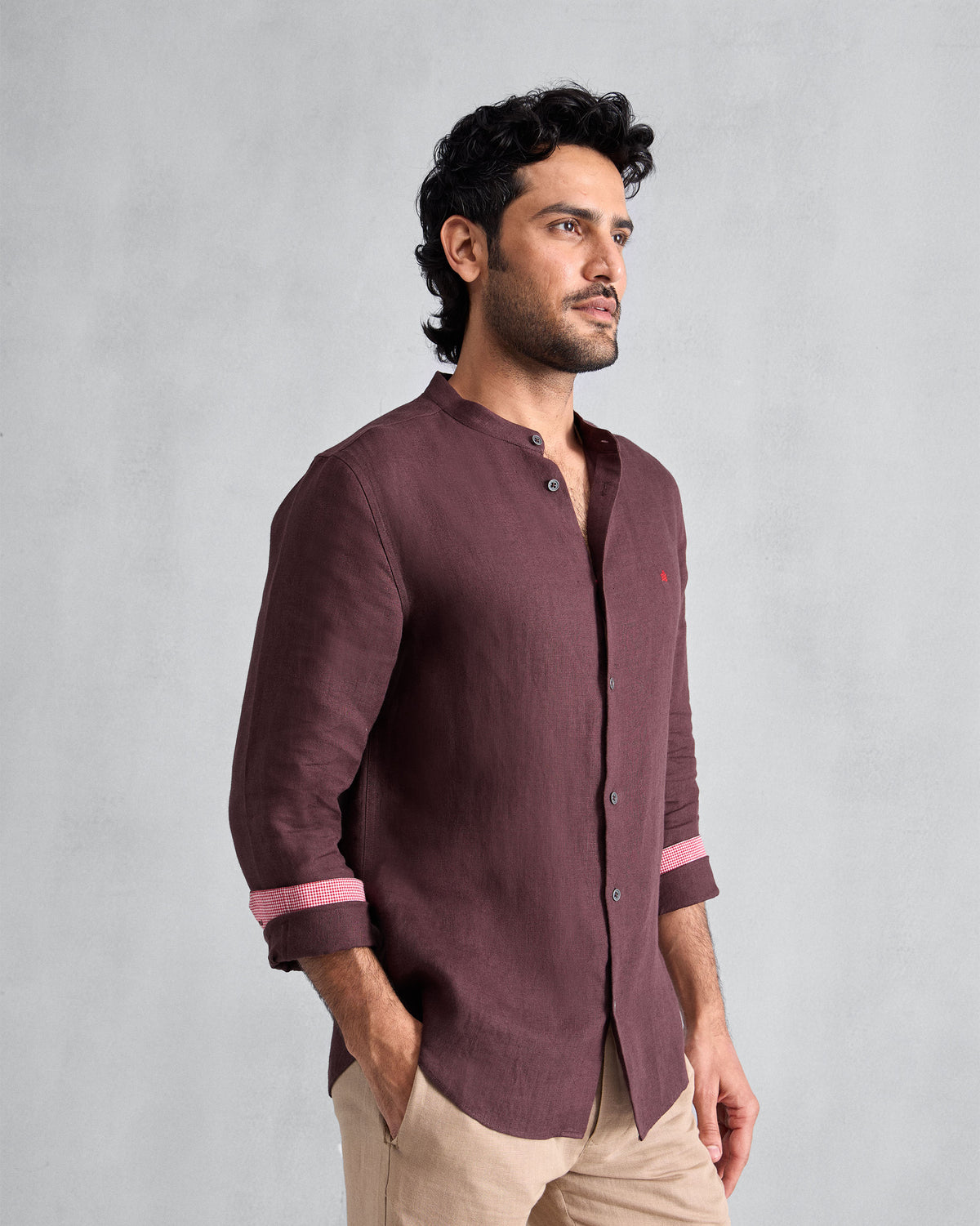 Three-quarter view of a chocolate plum Nawab Shirt with pink contrast cuff lining.