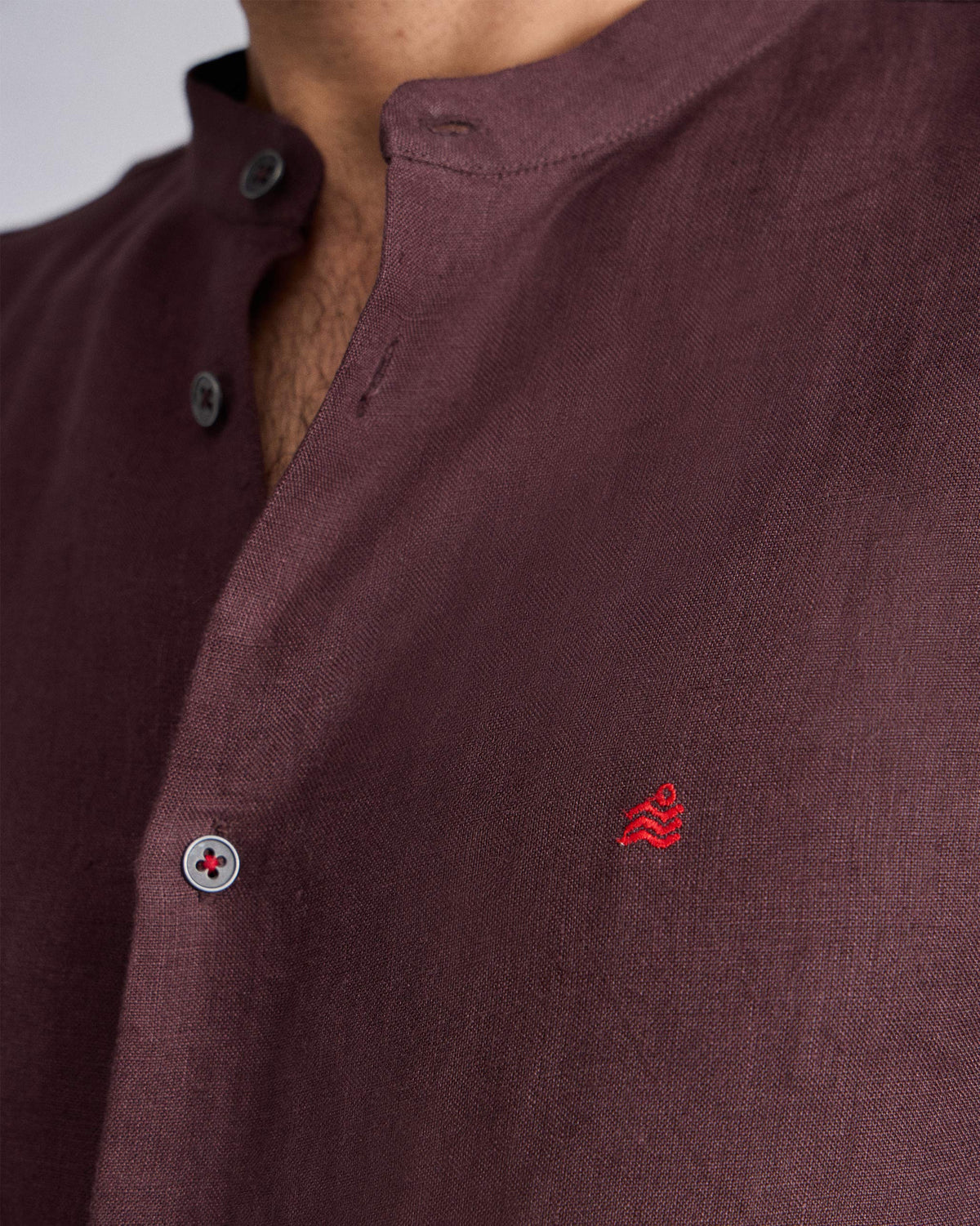 Close-up of a chocolate plum Nawab Shirt showing linen weave and a red chest logomark.