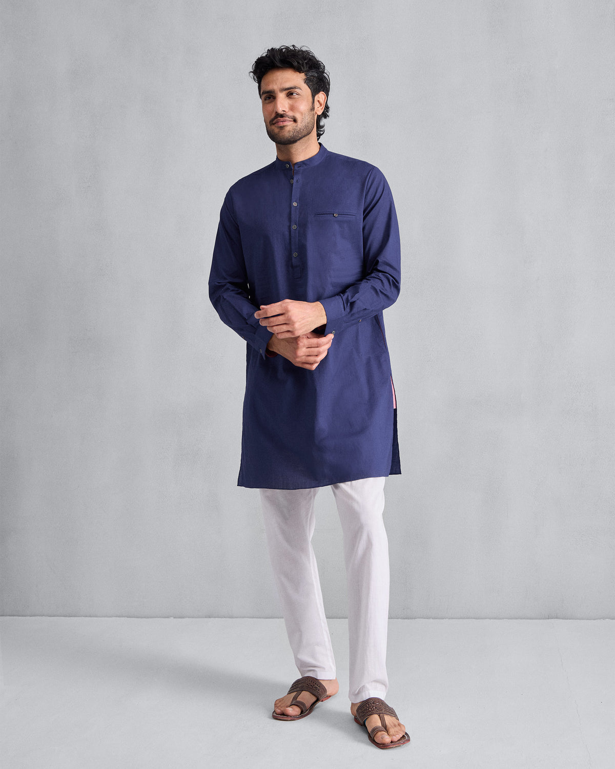 Person wearing an ink blue Pondicherry Kurta with full sleeves and a chest welt pocket.