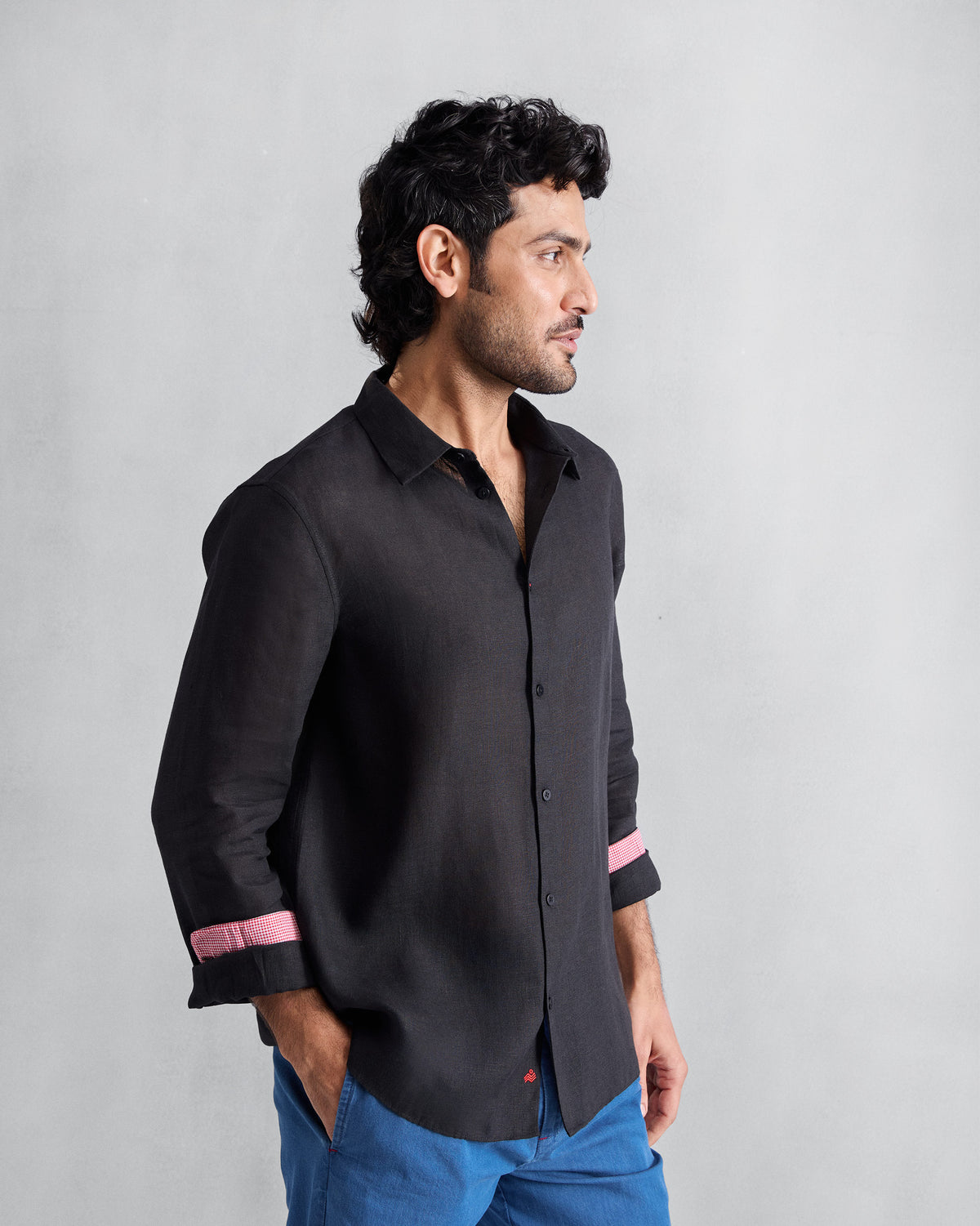 Side view of a black Classic shirt with pink cuff lining.