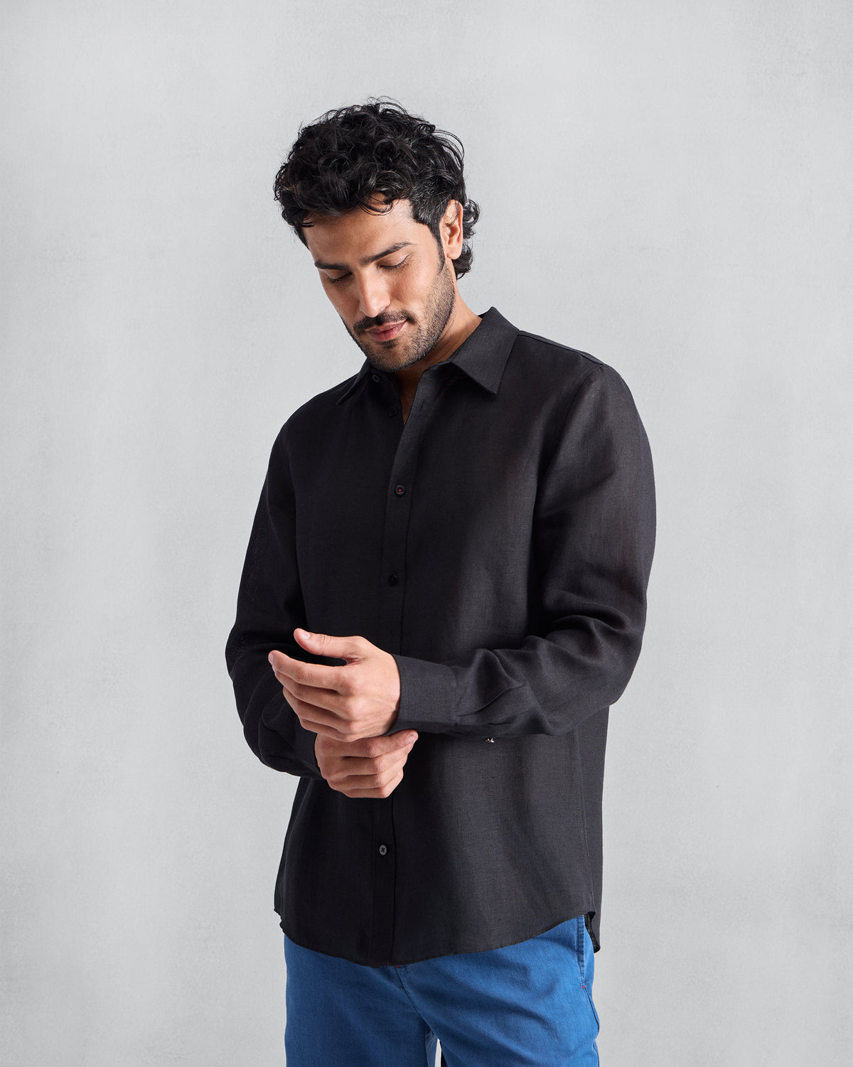 Person wearing a black Classic shirt with buttoned cuffs.