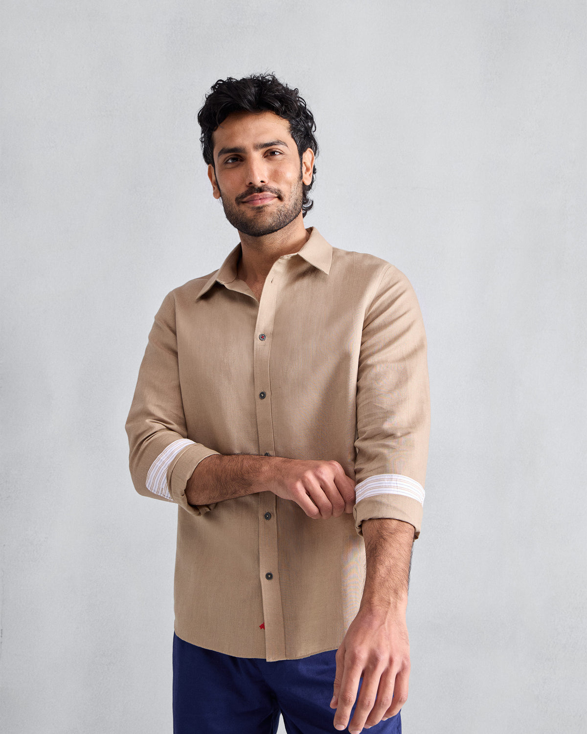 Person wearing a beige Classic shirt with rolled sleeves.