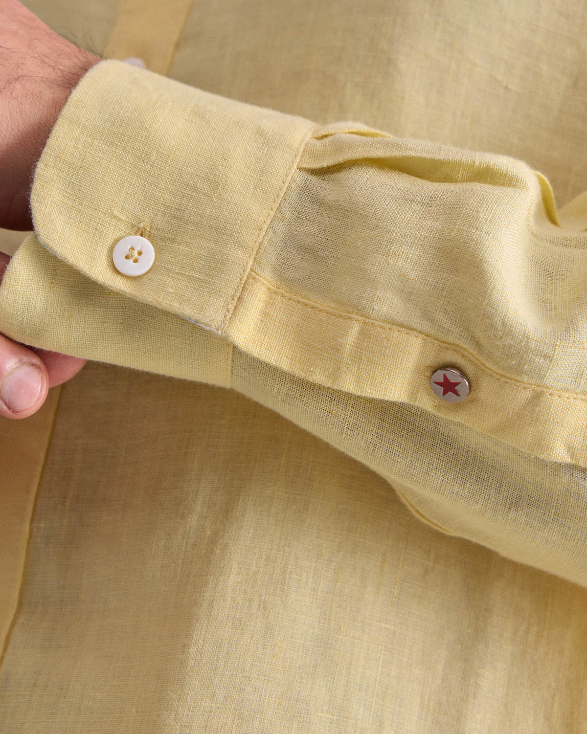 Close-up of a lemon Classic shirt cuff with a star button.