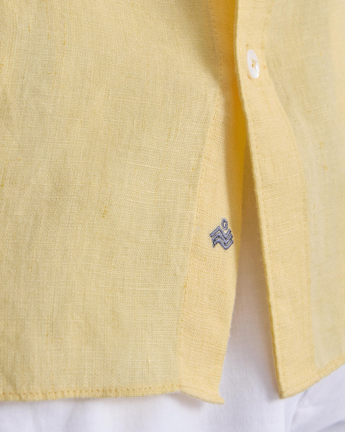 Close-up of a lemon Classic shirt hem with a side logo.