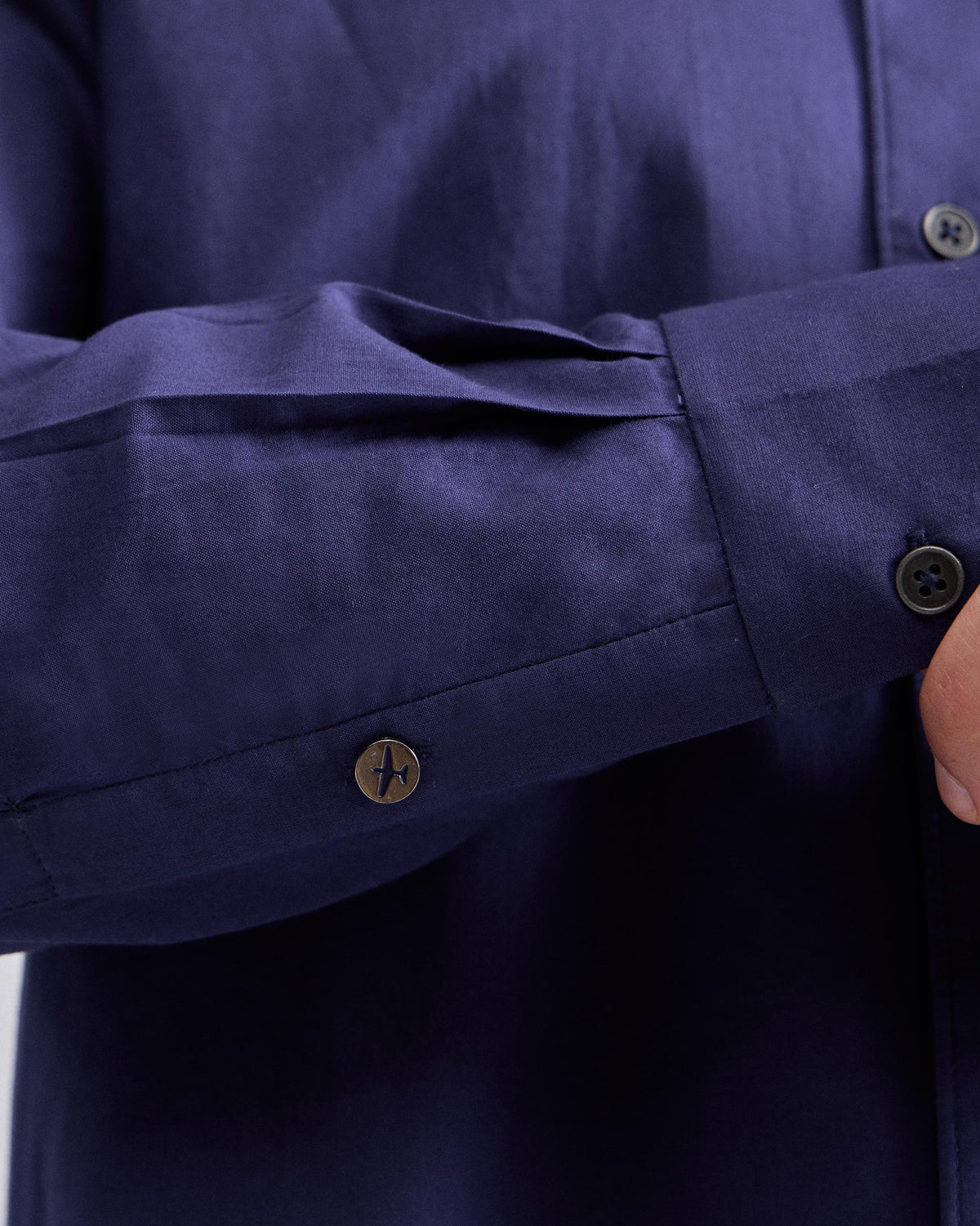 Close-up of an ink blue Classic shirt cuff with a plane button.
