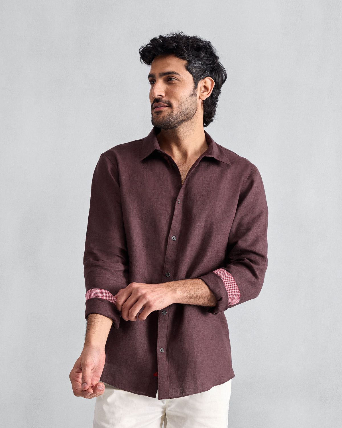 Person wearing a chocolate plum Classic shirt with pink cuff lining.