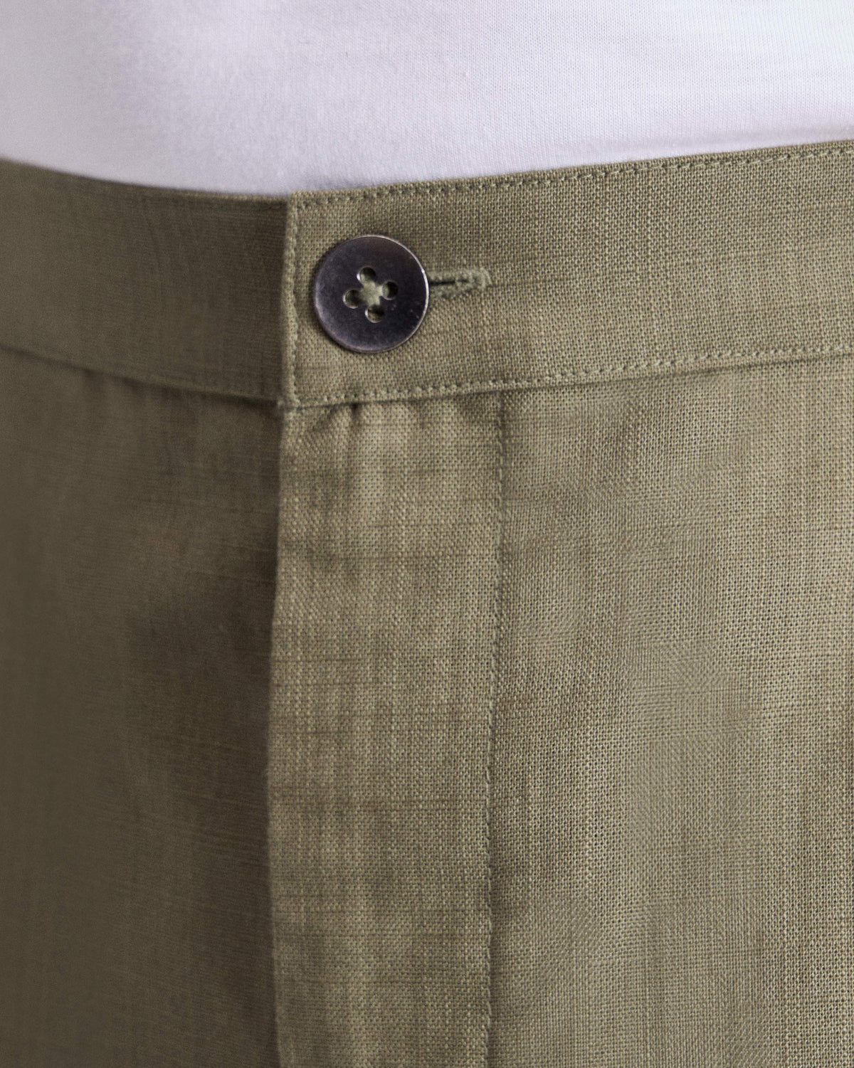 Close-up of olive Meadow Pants showing the button waistband and fly.