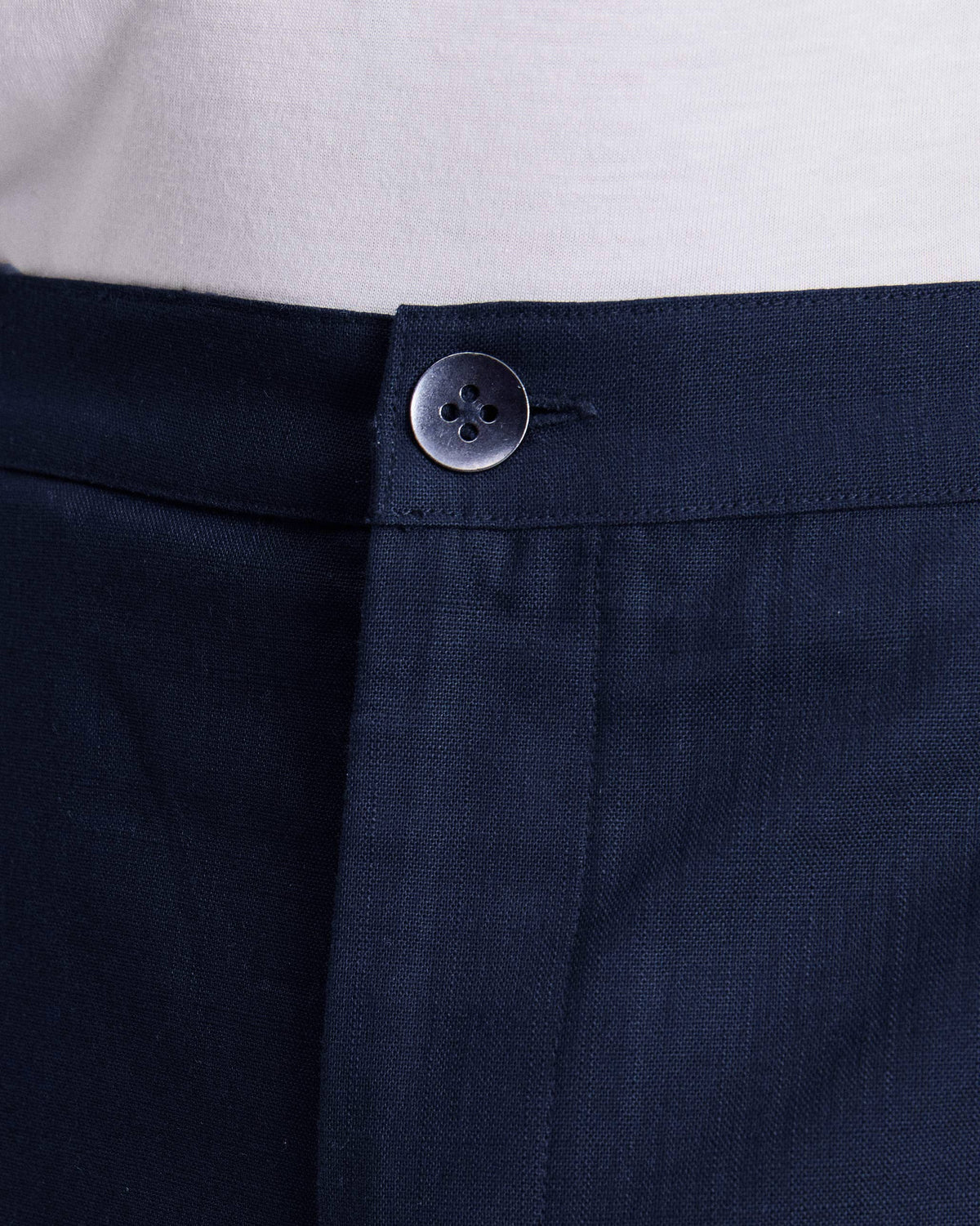 Close-up of orian blue Meadow Pants showing the button waistband and fly.