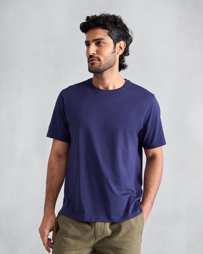 Person wearing an ink blue Everyday T-shirt with a crew neck.