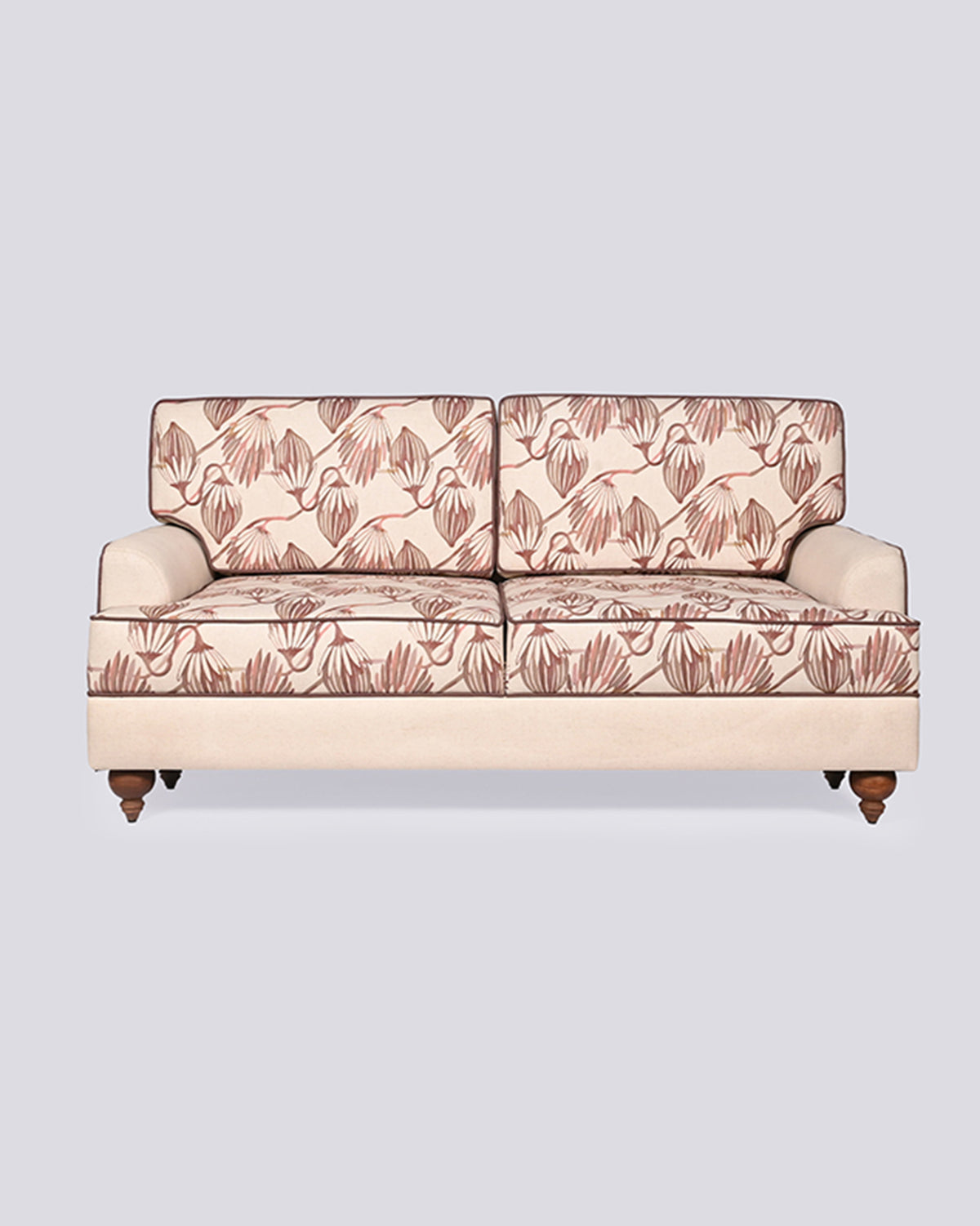 Field Sofa with terracotta botanical cushions and cream arms on wood legs.